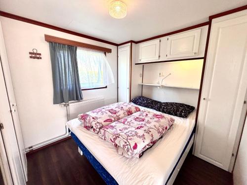 a small bedroom with a bed in a room at Northseachalets Ameland in Buren