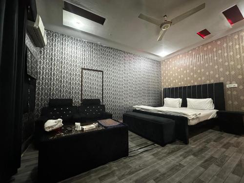 a living room with a bed and a couch at Hotel Sereena residence in Multan
