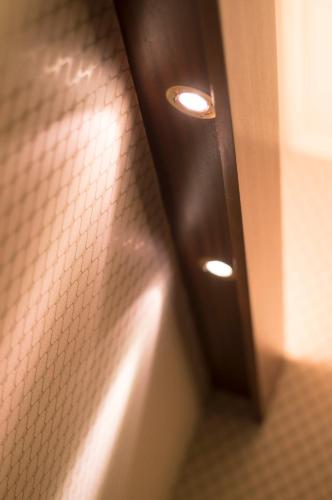 a bathroom stall with a door with lights on it at Hotel Polo in Rimini