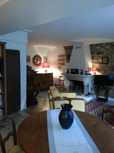 a living room with a table with a vase on it at GÎTE DU VALAMBOURG in Auvers-sur-Oise