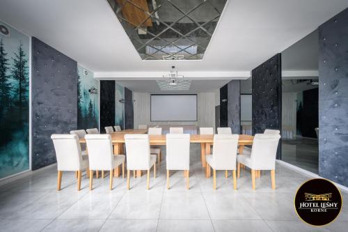 a conference room with a wooden table and white chairs at Hotel Leśny Korne koło Kościerzyny - Kaszuby in Korne