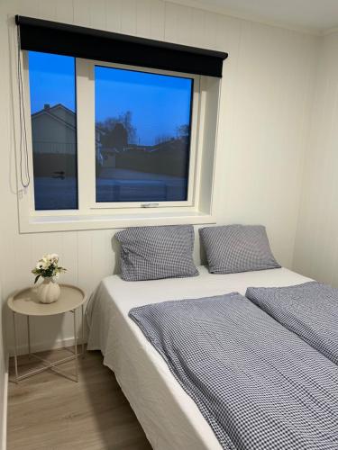 a bedroom with two beds and a window at GHAR-New 2 bedrooms apartment near airport and Oslo city-free parking in Klofta