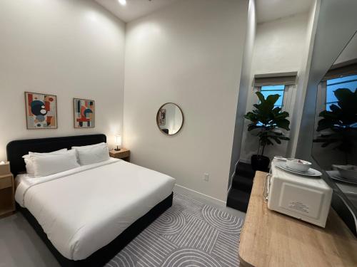 a bedroom with a white bed and a table at Hotel Royal in Long Beach