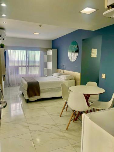 a bedroom with a bed and a table and chairs at HOTEL NAVEGANTES VISTA PARA MAR Boa Viagem in Recife