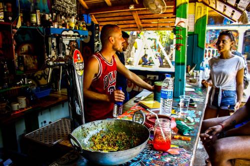 a man standing at a bar with a bowl of food at Pappi Chulo Vagator in Vagator