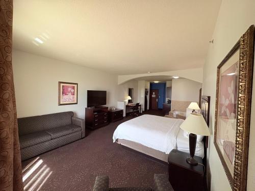 a hotel room with a bed and a couch at Country Inn & Suites by Radisson, Terrell in Terrell