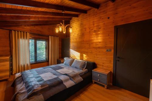 a bedroom with a bed in a room with wooden walls at Uludağ Vadi Konakları in Bursa
