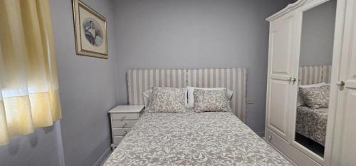 a small bedroom with a bed and a dresser at Apartamento Candil in Puerto Naos