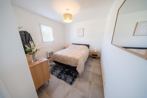 a bedroom with a bed and a dresser in a room at la pause soleil, villa climatisée, avec jardin et parkings privés, à 5 mn de la mer, au calme in Martigues