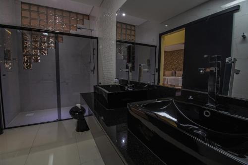 a large bathroom with two sinks and a shower at Hotel Franco Blumenau in Blumenau