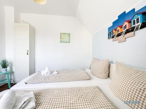 a bedroom with two beds and a painting on the wall at Hus Krüüzpadd boben in Cuxhaven