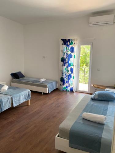 a room with three beds and a window at Blue Maris in Sutomore