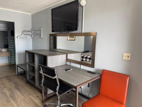a room with a desk and a mirror and a table and chairs at Travel Inn in Broadview