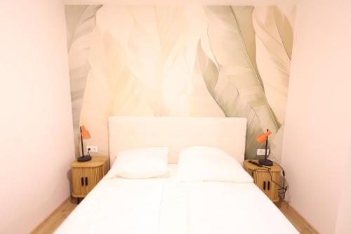 a bedroom with a white bed with two pillows at St Antoni Suite 4 in Eisenstadt