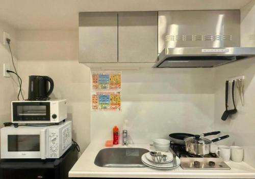 a small kitchen with a sink and a microwave at Sumida Ward - Hotel - Vacation STAY 00237v in Tokyo