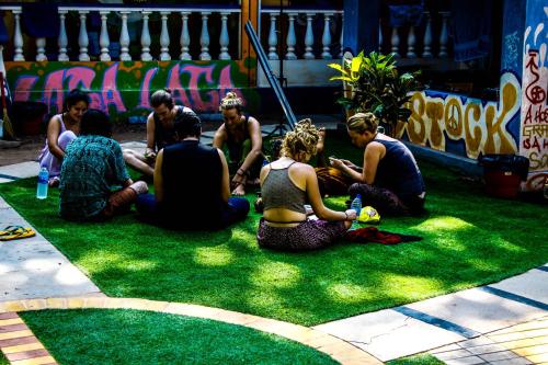 a group of people sitting on the grass at Pappi Chulo Vagator in Vagator