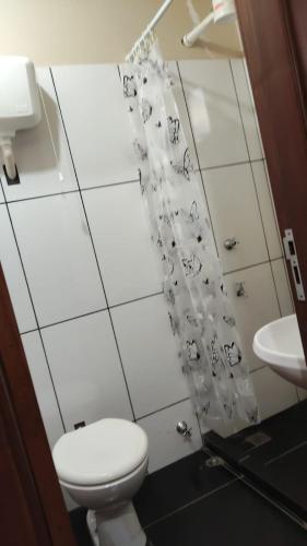 a bathroom with a toilet and a shower curtain at Ada 311b in Ciudad del Este