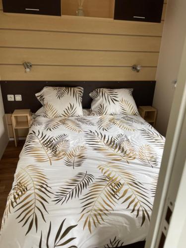 a bed with a black and white comforter and pillows at Lux in Saint-Pierre-dʼOléron