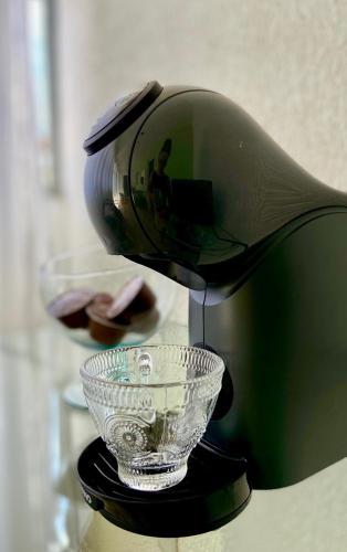 a coffee maker with a glass bowl on a table at Casa Freitas - suíte 1 in Extrema