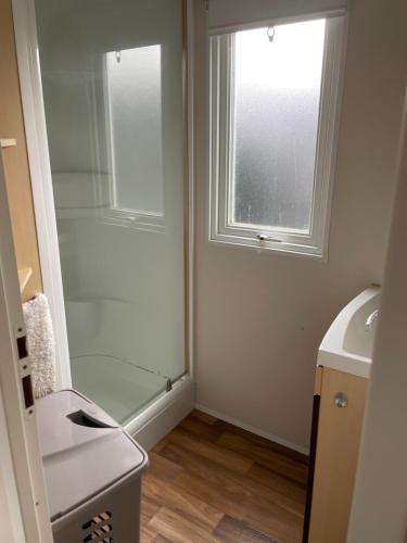 a bathroom with a shower and a sink and a window at Lux in Saint-Pierre-dʼOléron