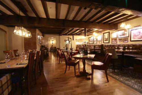 a restaurant with tables and chairs in a room at Crown Hotel in Nantwich