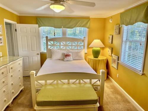 a bedroom with a bed in a room with yellow walls at Just Peachy in Myrtle Beach