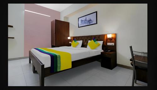 a bedroom with a large bed with a colorful blanket at Hotel Starwood Near Airport Road Sector 78 Mohali Chandigarh in Mohali