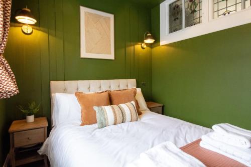 a bedroom with green walls and a white bed at Unique 1 Bed Apartment, Auchterarder in Auchterarder