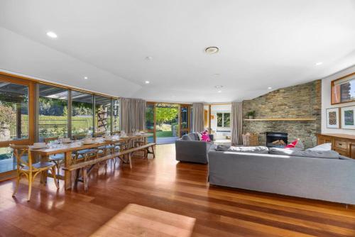 a living room with a couch and a table and a fireplace at Wanaka Lakeside Serenity at Eely Point with Pool in Wanaka