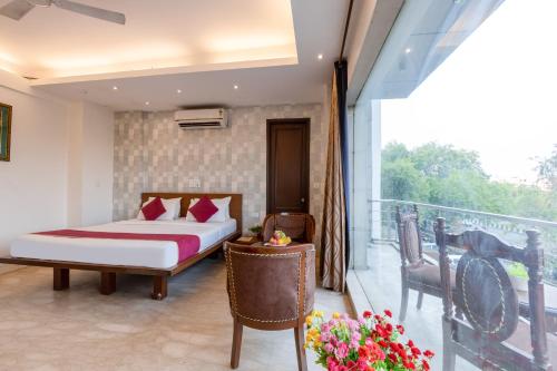 a bedroom with a bed and a balcony at Hotel The Imperio, Near Apollo Hospital, JASOLA in New Delhi