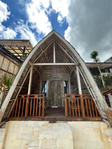 a small house with a thatched roof at Rice Field and Mountain View House in Karangasem