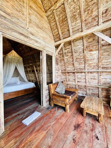 a room with a bed and a bench and a table at Rice Field and Mountain View House in Karangasem