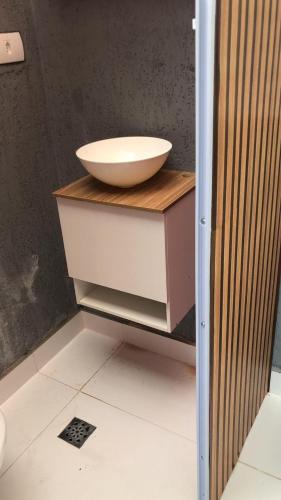 a bathroom with a bowl on top of a counter at Casa com piscina in Londrina