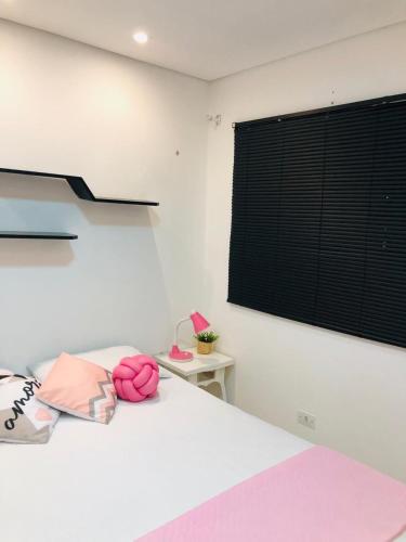 a bedroom with a bed and a window and a table at Casa com piscina in Londrina