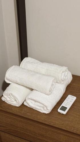 a stack of towels and a remote control on a table at Apto Centro de Sinop - 720C in Sinop