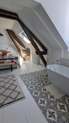 a attic bathroom with a tub and a bedroom at Maison Loire et Mer in Mer