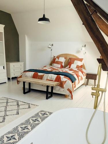 a bedroom with a bed and a bench at Maison Loire et Mer in Mer