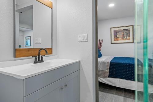 a bathroom with a sink and a mirror and a bed at Downtown Vibes Stylish Studio, Perfect Location in Tampa