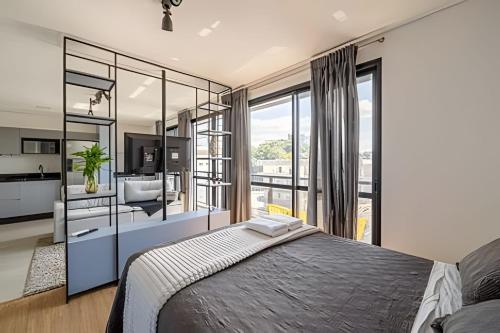 a bedroom with a large bed and a large window at Flipchave | Highline design in Joinville