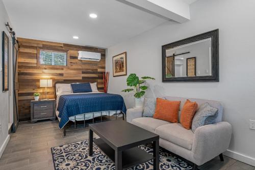 a bedroom with a bed and a couch and a table at Downtown Vibes Stylish Studio, Perfect Location in Tampa