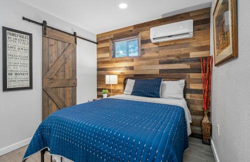 a bedroom with a blue bed and a wooden wall at Downtown Vibes Stylish Studio, Perfect Location in Tampa