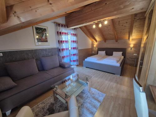 a living room with a couch and a bed at Hotel Gletschermühle in Flattach