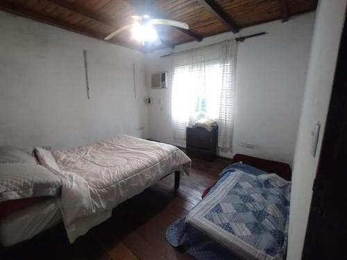 a small bedroom with a bed and a window at Casa Garú in Paso de los Libres