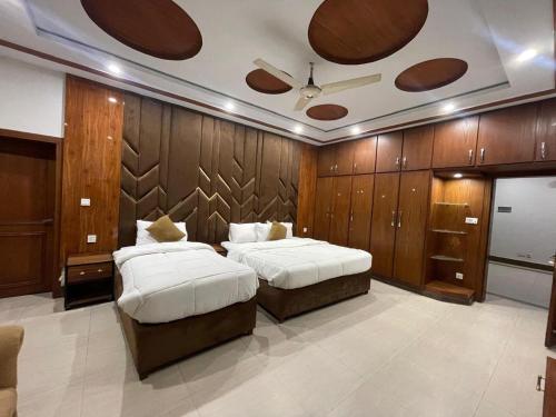 two beds in a room with wood paneling at Arizona 2 in Islamabad