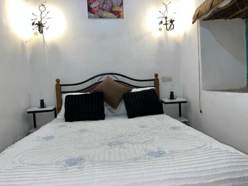 a bedroom with a white bed with two night stands at Riad dar khadija in Taroudant