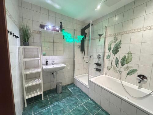 a bathroom with a tub and a sink and a shower at Fewo Auenblick in Ascheberg