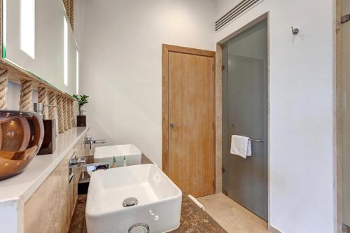 a white bathroom with a sink and a shower at Mystique Holbox by Royalton, A Tribute Portfolio Resort in Holbox Island