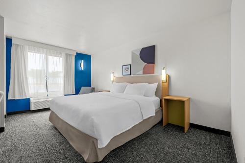 a bedroom with a large white bed and a window at Spark by Hilton Pelham Birmingham I 65 in Pelham