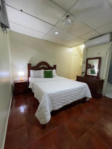 a bedroom with a large white bed and a mirror at VBermor Hotel in Santo Domingo