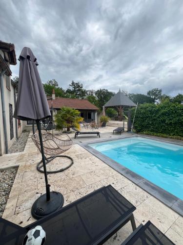 an umbrella sitting next to a swimming pool at Le Val Cosy in Montlivault